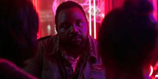 Brian Tyree Henry sitting in a brightly lit restaurant with Julian Dennison and Millie Bobby Brown in Godzilla vs Kong.