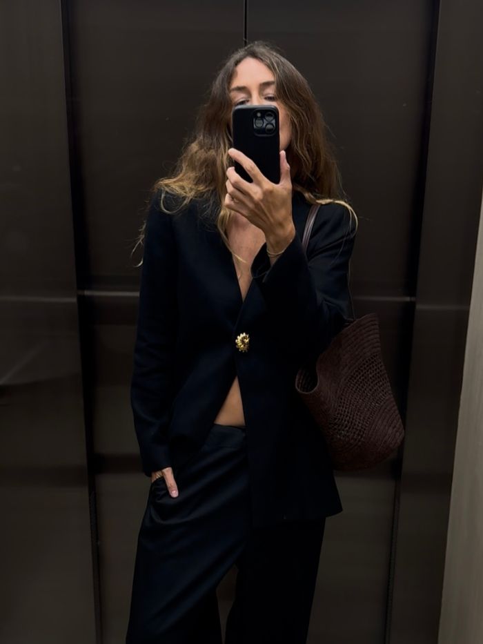 Angie wears a S&amp;eacute;zane blazer, black trousers and woven brown bag