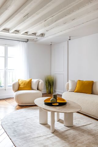 white minimal living room with mustard cushions