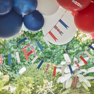 Red white and blue ballons and bunting hanging in garden