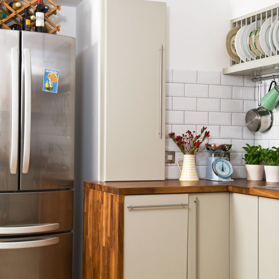 kitchen with white tiles on wall and fridge