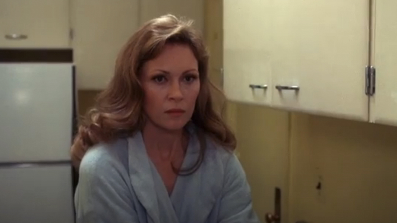 Faye Dunaway in a bathrobe looking upset and angry in a kitchen in Network