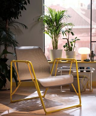 A lounge chair from IKEA's gaming collection in a white room with house plants