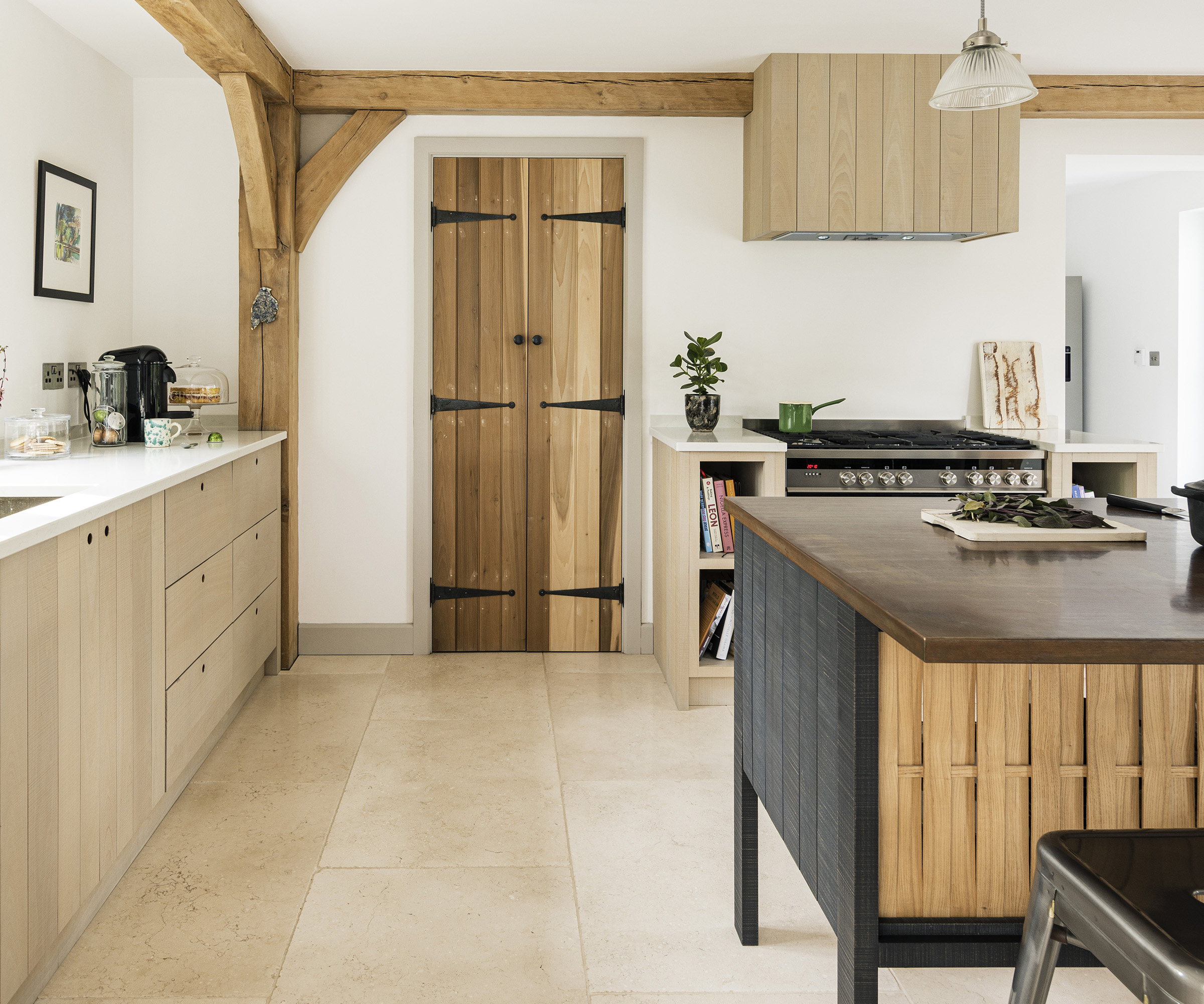A neutral kitchen with wooden cabinets and freestanding central island