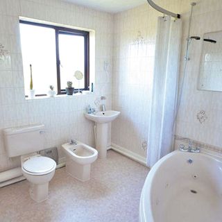 bathroom with corner bath and window