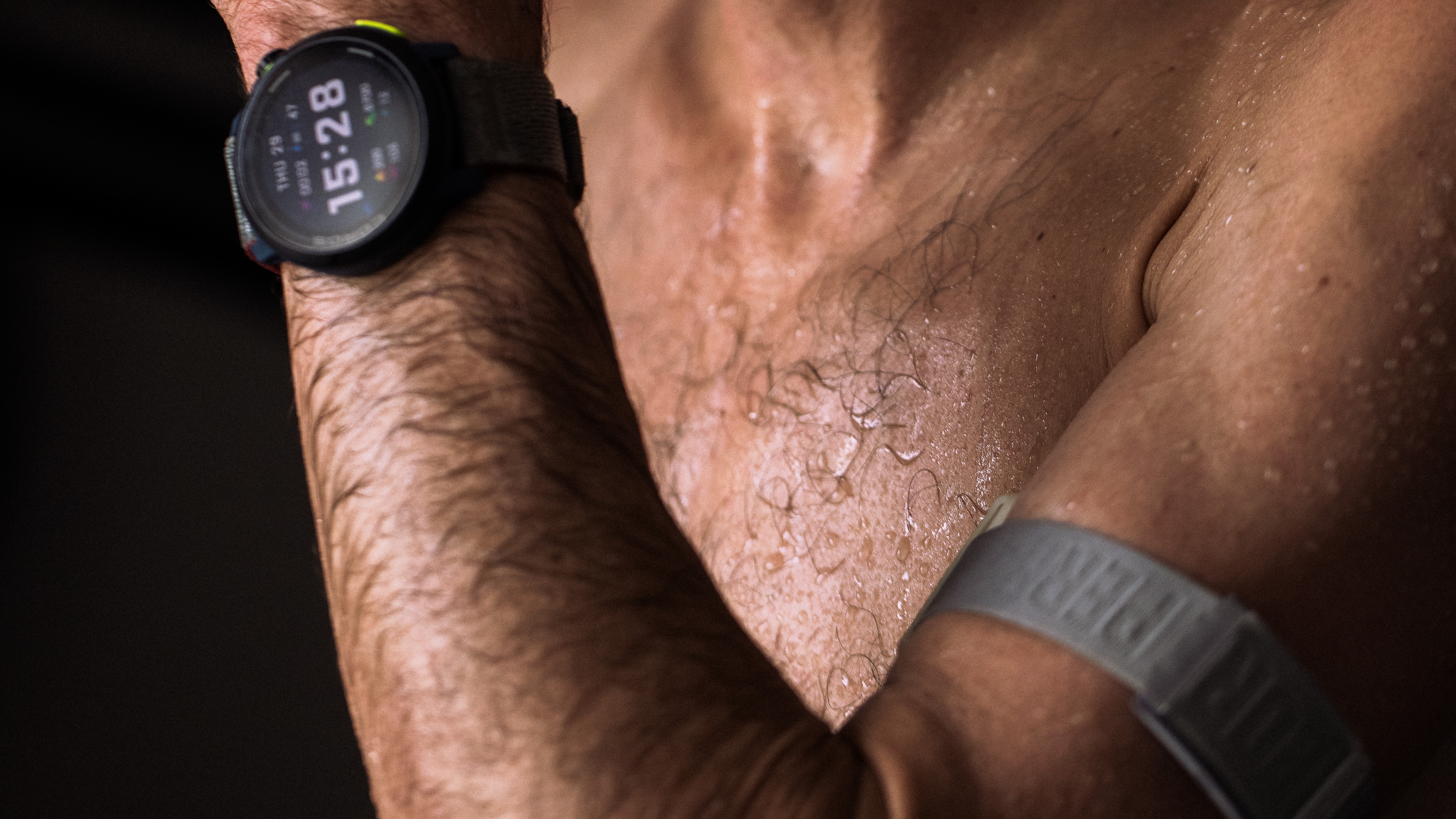 Close up of Kilian Jornet sweating during training with Coros Apex 2 Pro watch and Coros heart rate monitor arm band