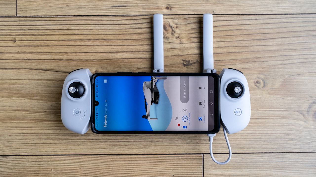 Potensic Atom SE controller with a smarta phone attached on a wooden floor