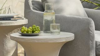 Magnolia glass carafe on a side table with grapes