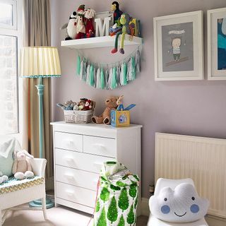 childrens room with white cupboard toys and floor lamp