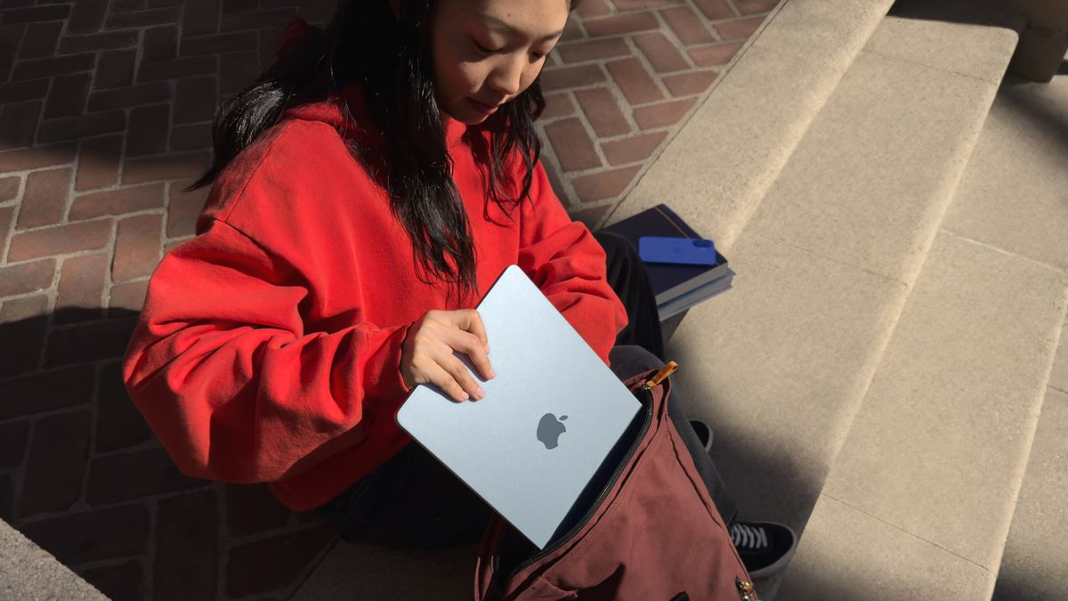 A person tucks the Apple MacBook Air M4 into a bag