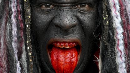 A performer with his face painted black poses for a portrait during the Day of Holy Innocents celebrations in Caucagua, Venezuela