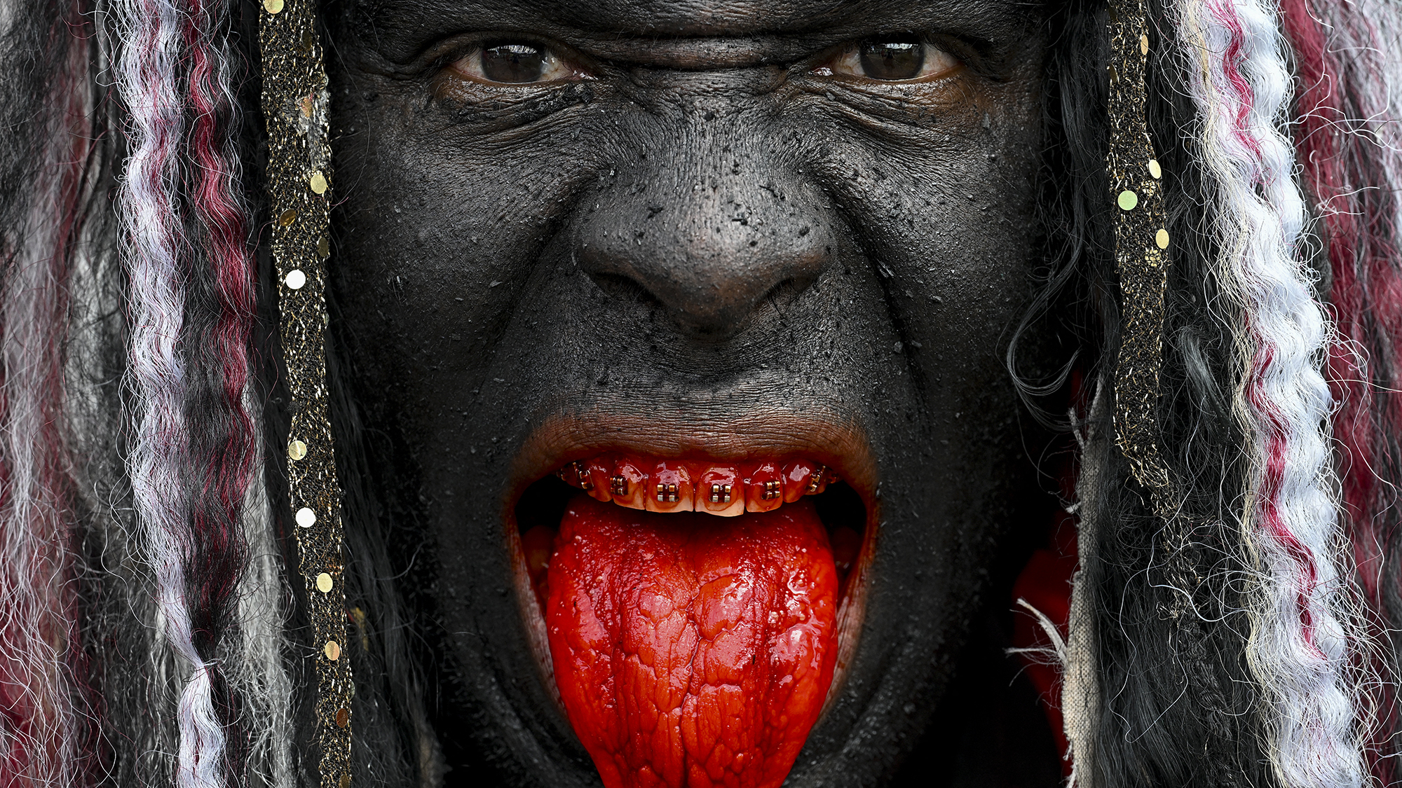 A performer with his face painted black poses for a portrait during the Day of Holy Innocents celebrations in Caucagua, Venezuela