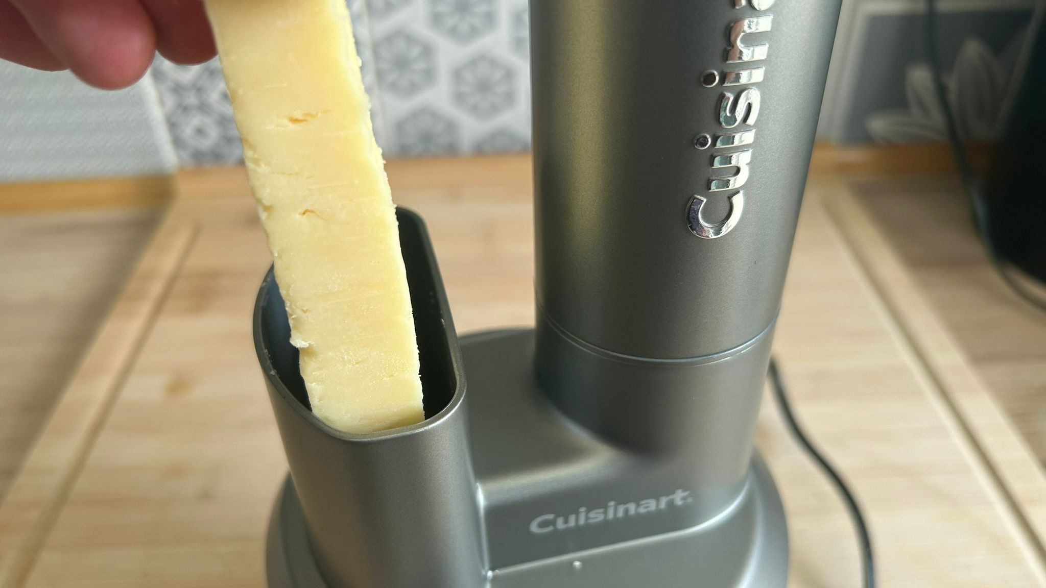 Feeding cheese into chute of Cuisinart Power Blend Immersion Blender