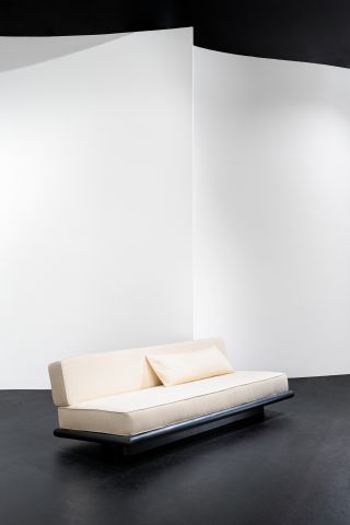 A white sofa with a black metal base.