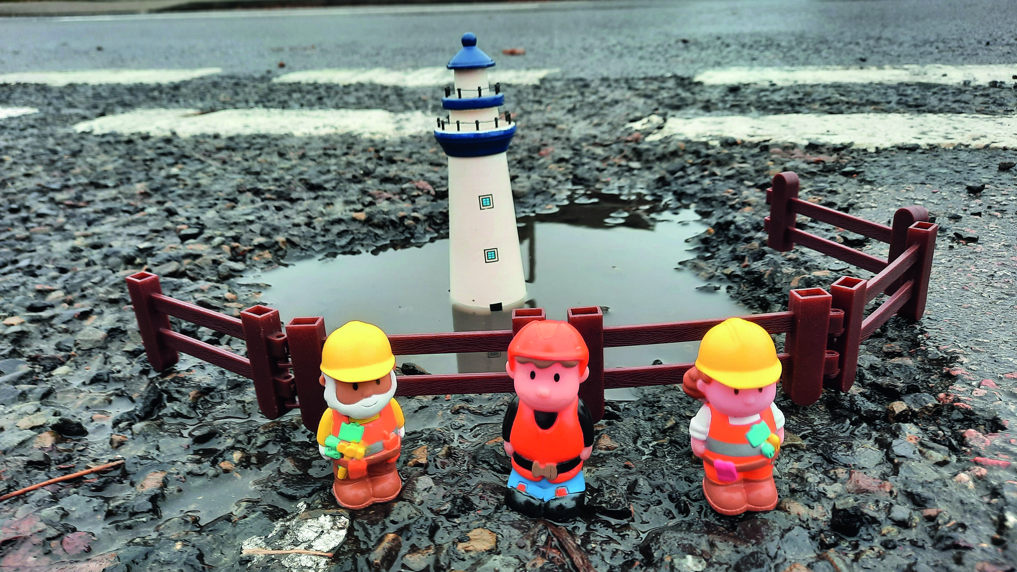 A pothole is dressed up as a lighthouse, with a model, by Tim Webb