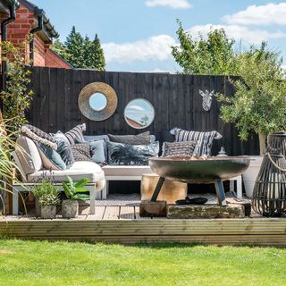 Outdoor living room with firepit and mirrors on decking platform