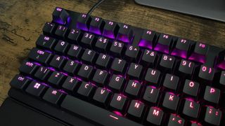 A closeup of the Razer Huntsman V3 Pro keys which are backlit with purple and pink lighting.
