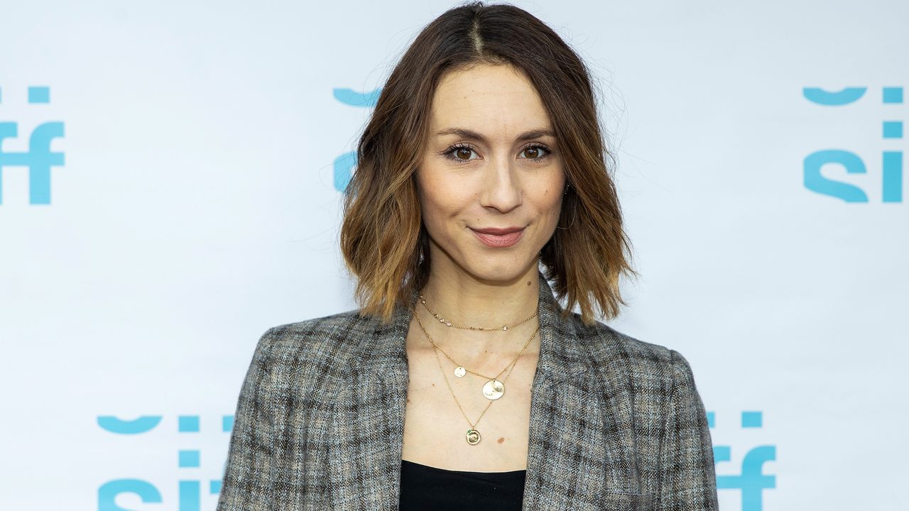 Troian Bellisario&#039;s living room is cozy and inviting. Here she is, a white woman with a brown bob, pictured in tweed blazer on red carpet