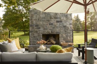 A backyard with an outdoor living room and fireplace