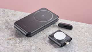 The components of the ESR Qi2 3-in-1 travel wireless charger sit on a stone-effect surface in front of a pink background.