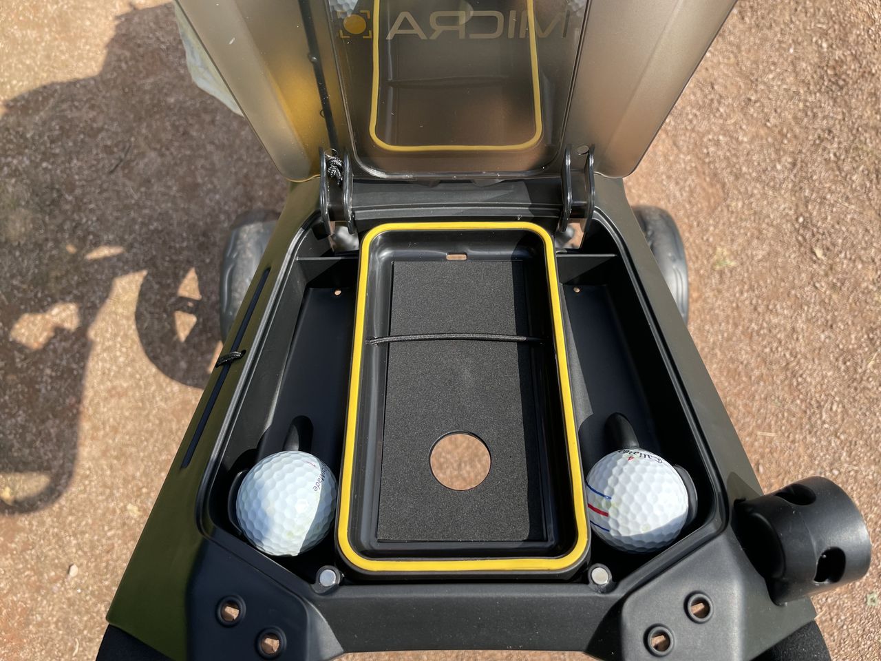 The storage space in the handle of the PowaKaddy Micra Push Cart with two golf balls