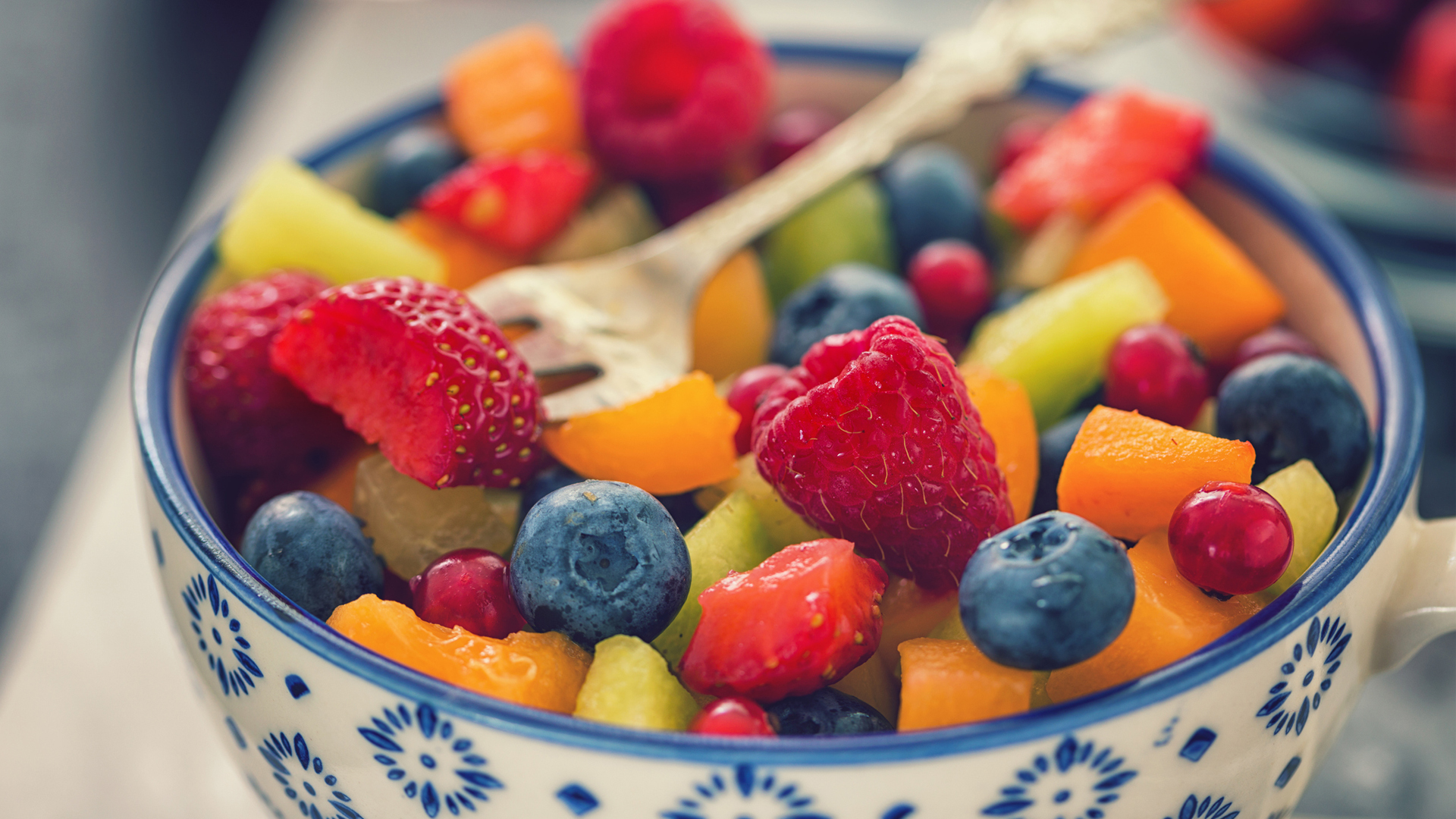 bowl of mixed fruit, including berries, strawberries and melon