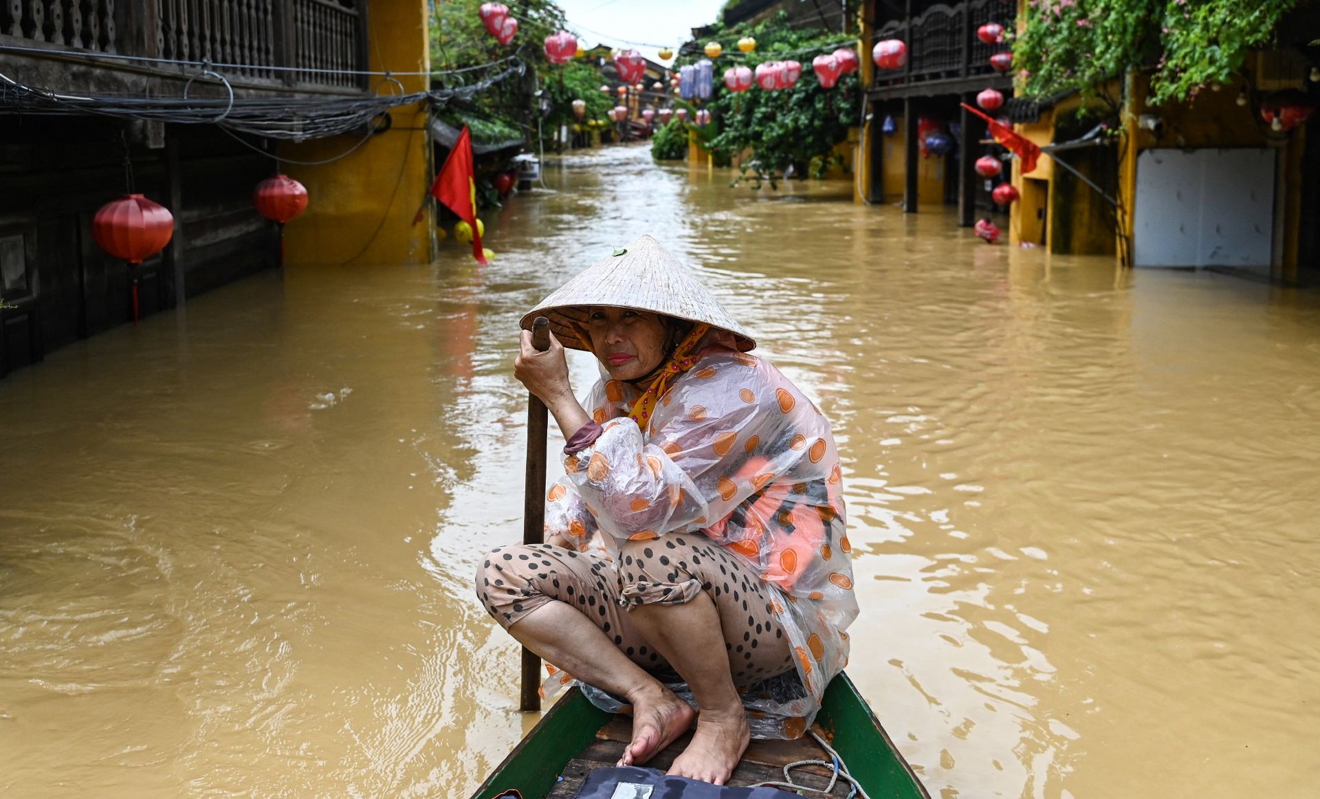 
                                A woman steers a boat along a flooded street in the port city of Hoi An, Vietnam
                            