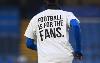 Detail view as Brighton & Hove Albion players warm up wearing a t-shirt with a message in protest against the European Super League prior to the Premier League match between Chelsea and Brighton & Hove Albion at Stamford Bridge on April 20, 2021 in London, England. Sporting stadiums around the UK remain under strict restrictions due to the Coronavirus Pandemic as Government social distancing laws prohibit fans inside venues resulting in games being played behind closed doors