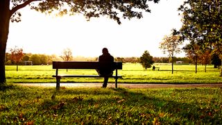 man sat alone on a park bench