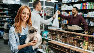 Lady in pet shop with dog under arm