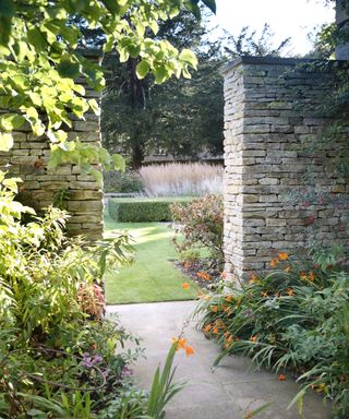 reclaimed stone wall separating different zones in a garden