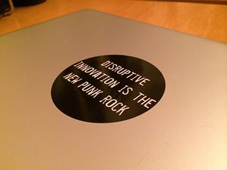 The sticker on my laptop lid, reading "Disruptive innovation is the new punk rock"
