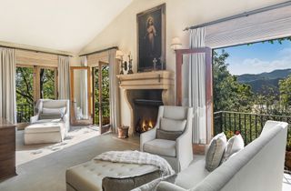 A neutral sitting room with fireplace and views in Sugar Ray Leonard's house