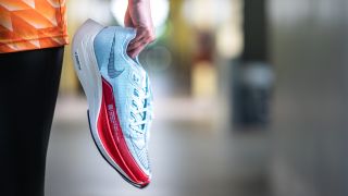 A runner holding a pair of the Nike Vaporfly Next% 2 