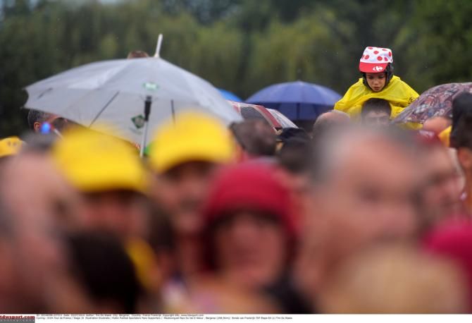 A young fan in yellow cheers on the peloton