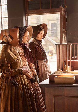 Scene from Emily, with 3 characters in a shop — the Emily Bronte movie