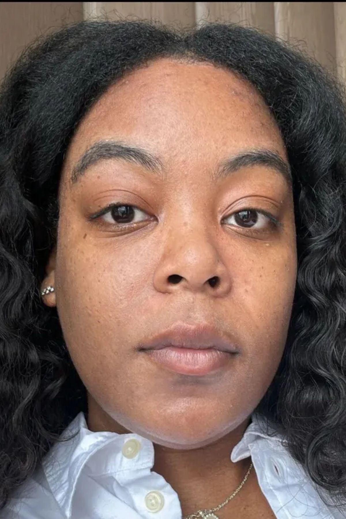 Ariel Baker before testing the Haus Labs Triclone Skin Tech Foundation wearing a grey sweater with a white collar.