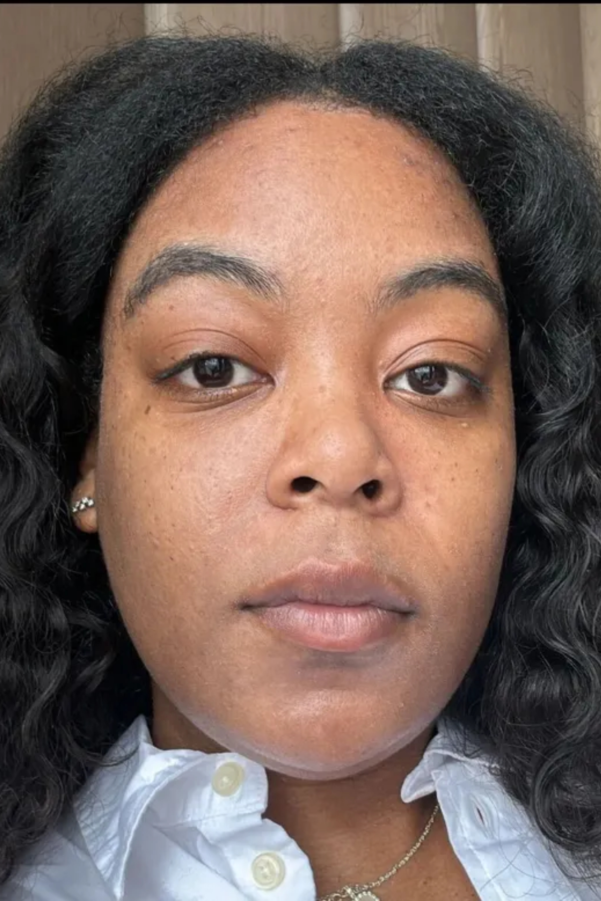 Ariel Baker before testing the Haus Labs Triclone Skin Tech Foundation wearing a grey sweater with a white collar.