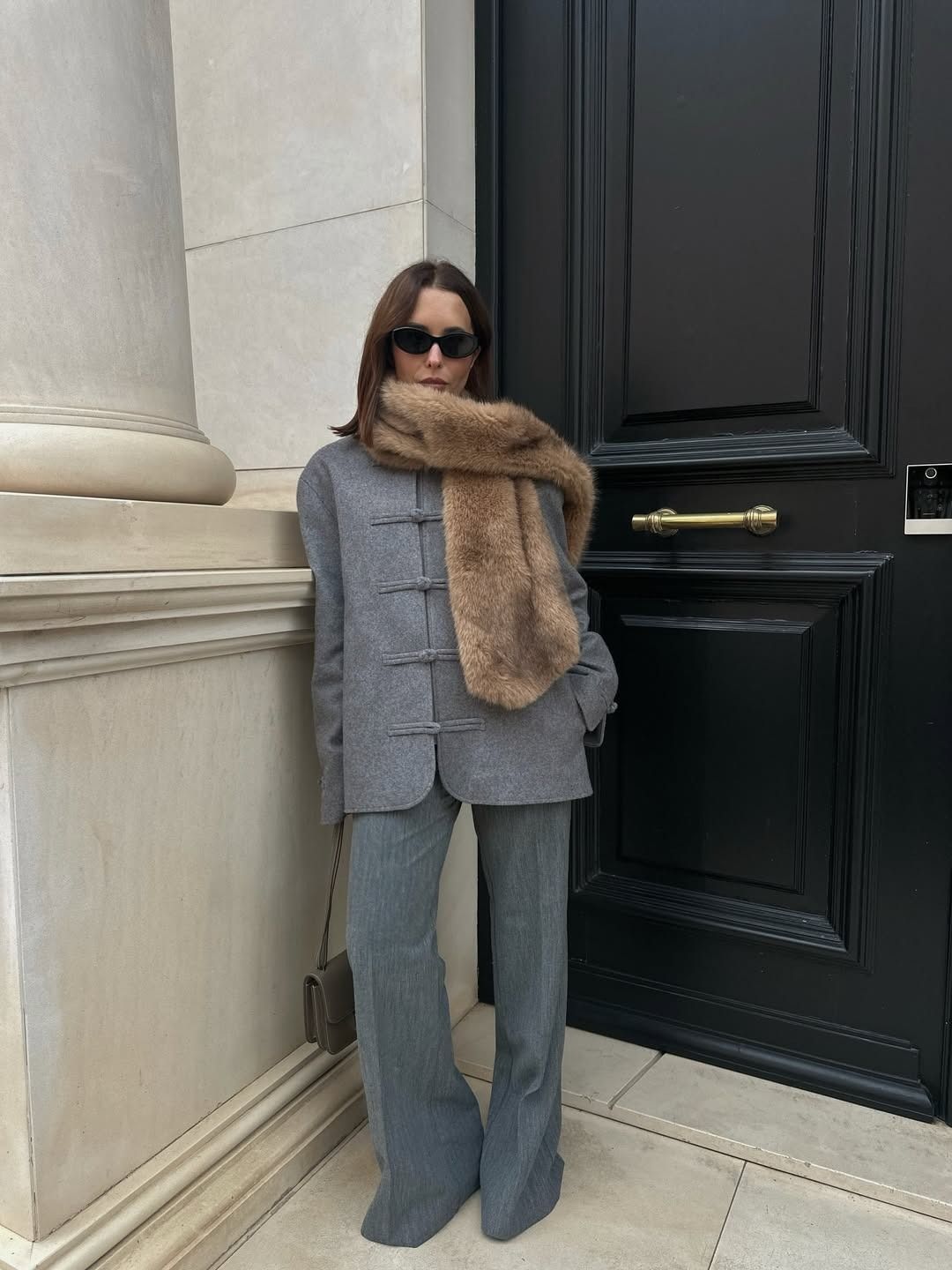 Woman in gray coat and brown faux-fur scarf.