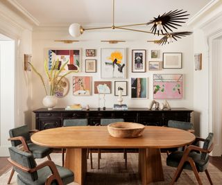 A dining room with a colorful gallery wall