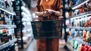 woman carrying a basket in a grocery store