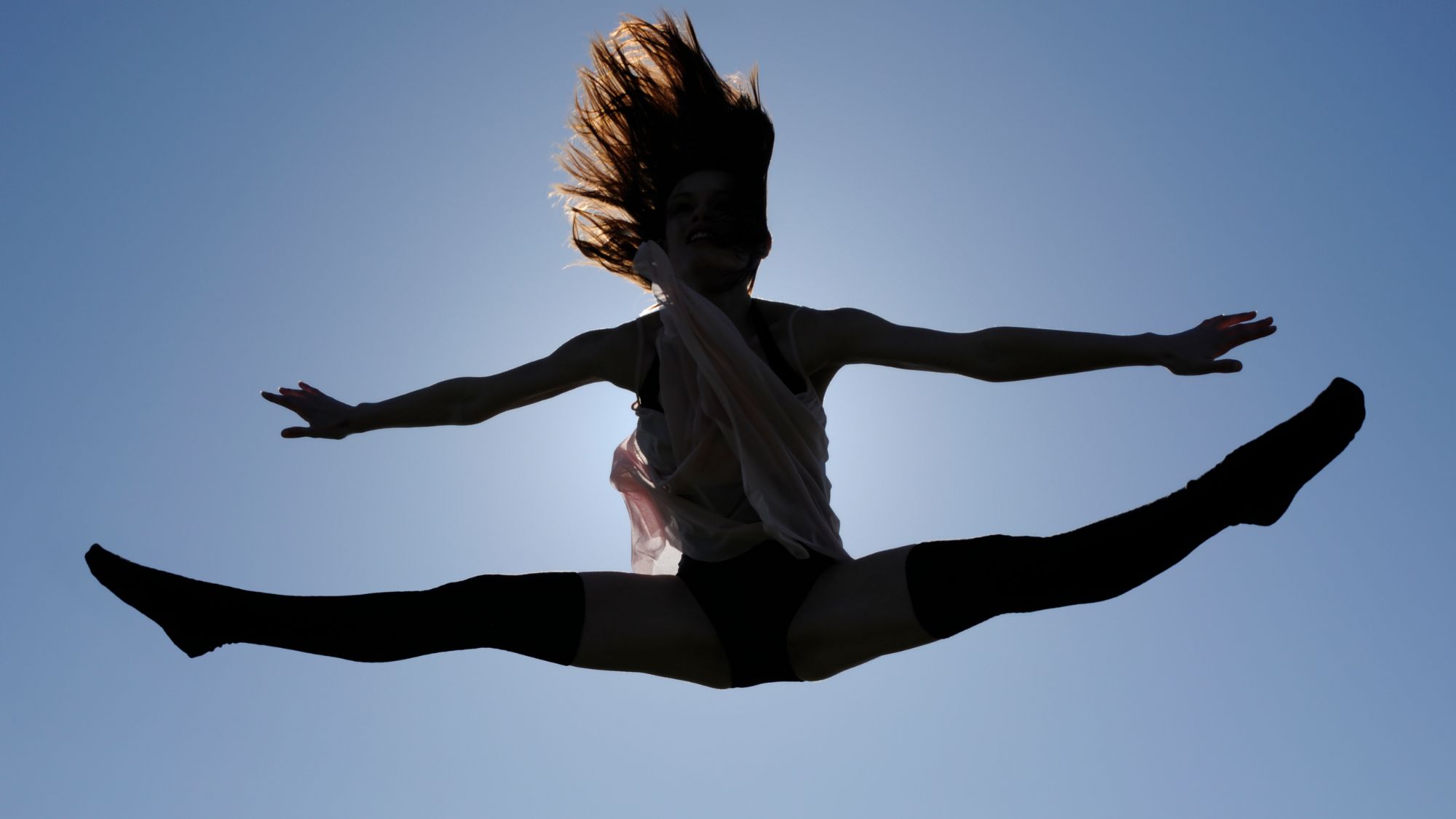 A woman trying rebounding: Doing the splits in the air