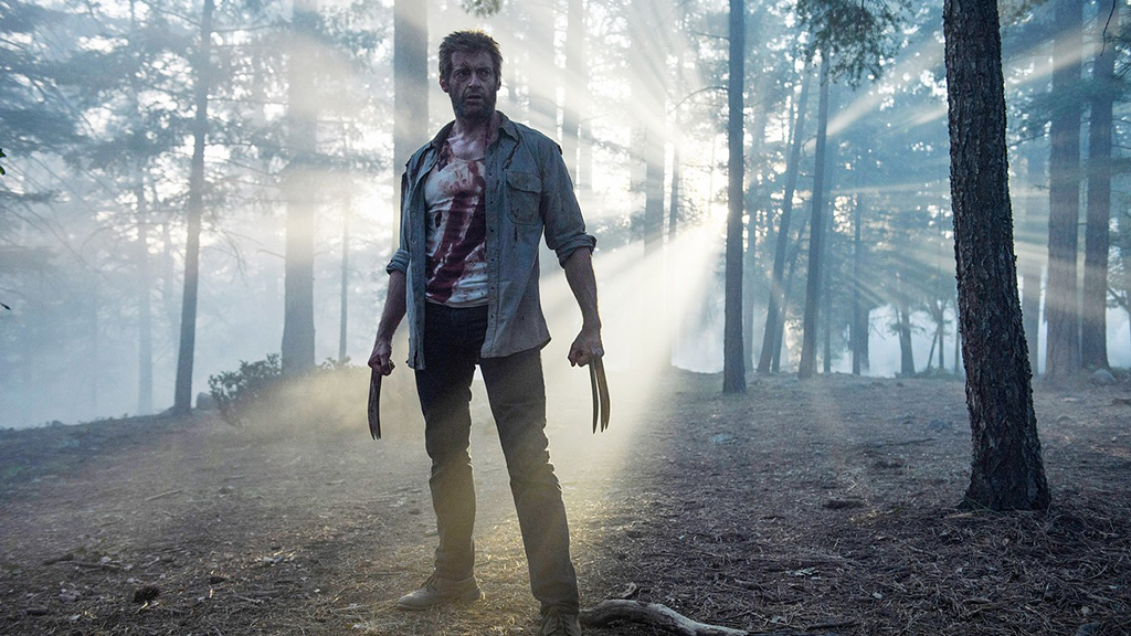 Hugh Jackman as Wolverine standing in a forest in Logan