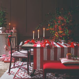 A dining room in a red and white colour scheme with the table set for a Christmas dinner