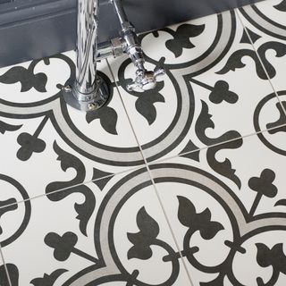 bathroom makeover with patterned black and white tiles