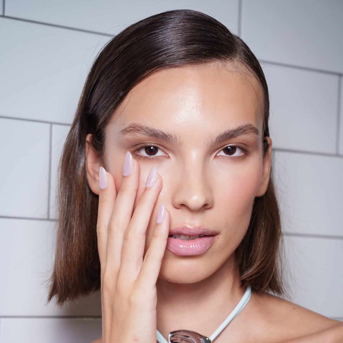 woman with oval nails putting her hand on her face