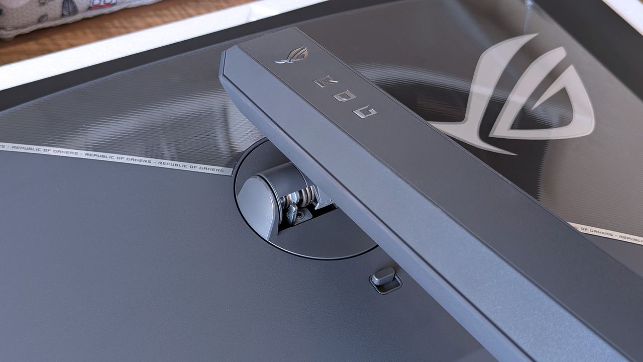 ASUS ROG Strix OLED stand mounting arm with the ROG logo and push-release button in view.