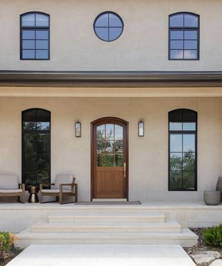 A modern home exterior with steps and a wooden front door