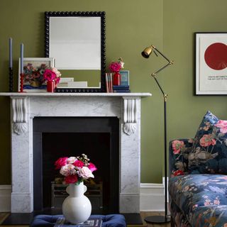 Green living room with period fireplace and artwork and mirror above