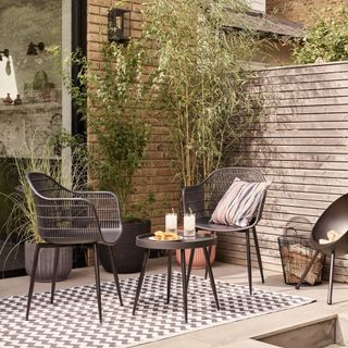 Patio with two black metal chairs and small coffee table